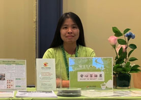photo of Kaiwen Zhang sitting at CACCC booth