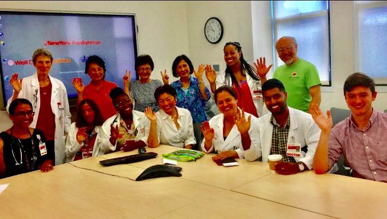 participants waving at camera around a table