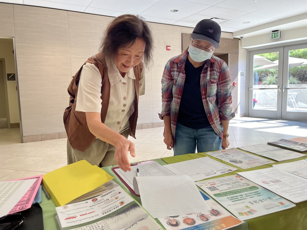 Attendees looking at a table of end of life care materials