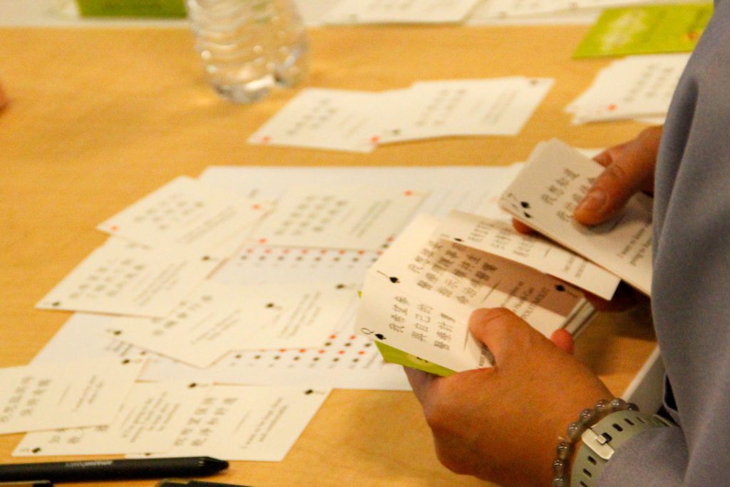 individual sorting through pile of heart to heart cards on table