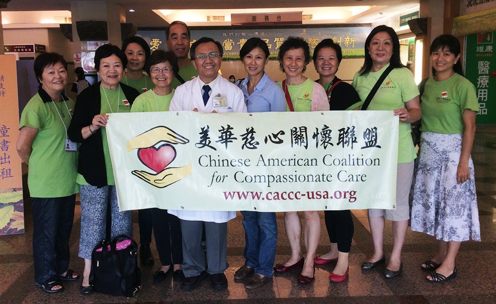 CACCC staff and volunteers standing together holding banner in 2014