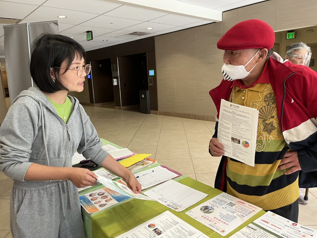 CACCC volunteer presenting forms to attendee
