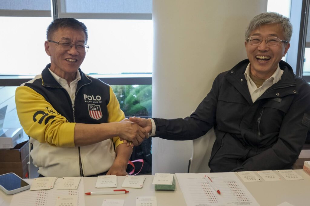 Attendees smiling and shaking hands at event