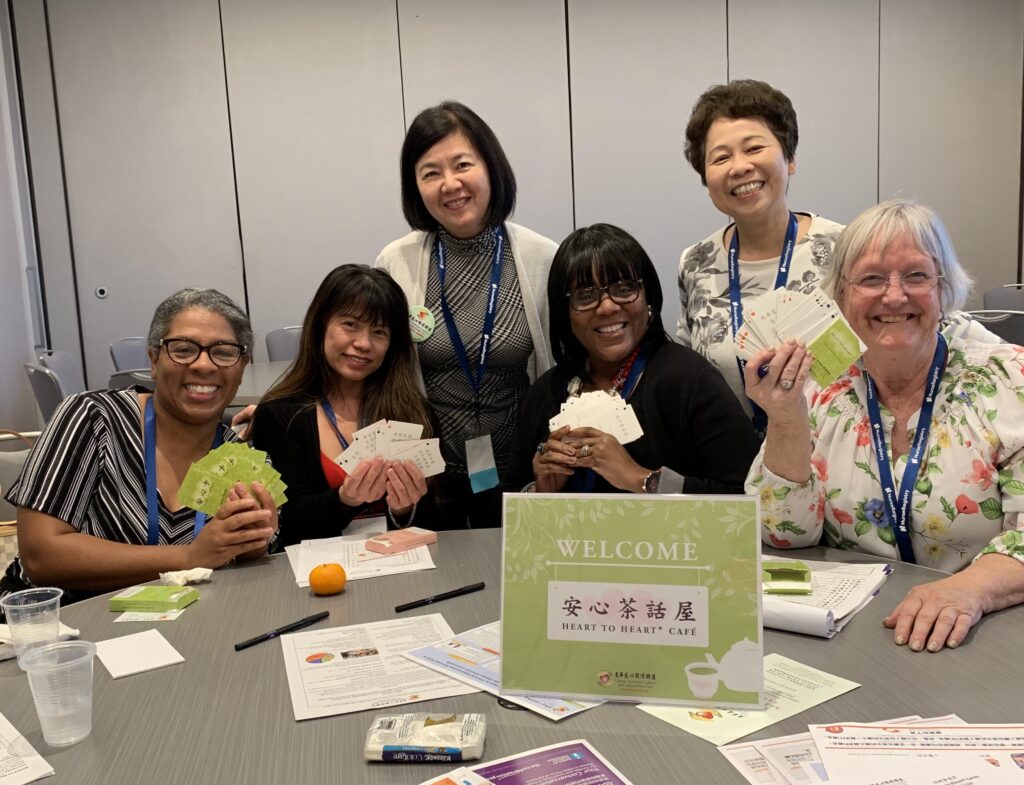 Smiling attendees at event holding up Heart to Heart cards